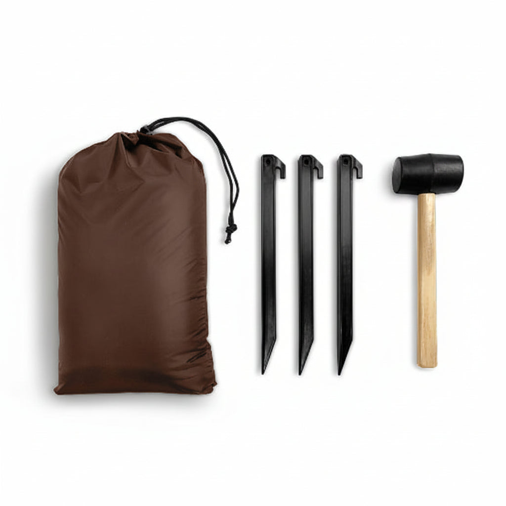 Brown drawstring bag, three black tent stakes, and a wooden mallet on a beige background